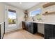 Stylish wet bar featuring dark cabinetry, quartz countertops, open shelving, and access to a deck at 4570 N Raleigh St, Denver, CO 80212