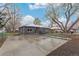 Beautiful single-story home with a large driveway and mature trees in the front yard at 5174 Dudley St, Arvada, CO 80002