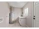 Bright laundry room with white cabinetry, countertop, and a utility sink at 5174 Dudley St, Arvada, CO 80002