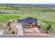 Expansive aerial view of the home showcasing its stone and gray siding, manicured landscaping, and sprawling green surroundings at 9727 Red Primrose St, Franktown, CO 80116