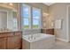 Bathroom offers dual vanities, a soaking tub under bright windows, and a serene design at 9727 Red Primrose St, Franktown, CO 80116