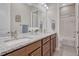 Bathroom with wood cabinetry, granite counters, and dual sinks at 9727 Red Primrose St, Franktown, CO 80116