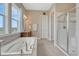 Bright bathroom features a large soaking tub, walk-in shower, and neutral tones throughout at 9727 Red Primrose St, Franktown, CO 80116