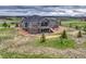 Spacious home with a stone and gray siding exterior, large windows, and a walkout balcony, offering scenic views at 9727 Red Primrose St, Franktown, CO 80116