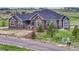 Charming single-Gathering home with a stone and siding exterior, complemented by a landscaped front yard with young trees at 9727 Red Primrose St, Franktown, CO 80116