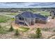 A luxurious home with a walkout balcony and stone and siding exterior, set on a large lot with landscaped surroundings at 9727 Red Primrose St, Franktown, CO 80116