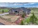 Beautiful home featuring a combination stone and gray siding exterior, a well-manicured lawn, and mature landscaping at 9727 Red Primrose St, Franktown, CO 80116