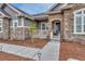 Inviting front entrance with a charming porch, stone accents, and manicured landscaping at 9727 Red Primrose St, Franktown, CO 80116
