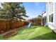 A well-maintained backyard featuring a playground, artificial turf, and a designated firepit area at 17613 E Ohio Cir, Aurora, CO 80017