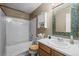 A quaint bathroom featuring a tub and shower combo, vanity, and wall storage at 17613 E Ohio Cir, Aurora, CO 80017