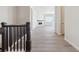 Bright hallway with dark wood railing and laminate wood flooring at 4704 Twelve Oaks Way, Castle Rock, CO 80104