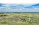 Panoramic aerial shot capturing the community with homes nestled amidst rolling hills and expansive green fields at 555 Heritage Trl, Elizabeth, CO 80107