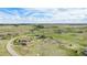 Expansive aerial view showcasing the community's homes set amidst vast fields with paved roads under a partly cloudy sky at 555 Heritage Trl, Elizabeth, CO 80107