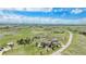 An aerial view of a house that features a well-kept backyard set amidst expansive fields with paved roads at 555 Heritage Trl, Elizabeth, CO 80107