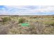 Scenic view of a home set on a vast, open field with scattered houses, trees, and a glimpse of a green putting green at 555 Heritage Trl, Elizabeth, CO 80107