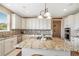 Bright kitchen featuring a large island with a granite countertop, white cabinetry, and modern appliances at 555 Heritage Trl, Elizabeth, CO 80107