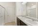Bathroom featuring double sinks, a walk-in shower, and a large mirror at 13487 Valentia St, Thornton, CO 80602