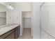 Bathroom with dual sinks, walk-in shower and doorway to walk-in closet at 13487 Valentia St, Thornton, CO 80602