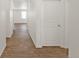 Bright hallway with wood-look flooring and white walls, leading to a sunlit room at 13487 Valentia St, Thornton, CO 80602