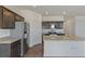 Bright kitchen with stainless steel appliances, dark cabinets, and granite island with sink at 13487 Valentia St, Thornton, CO 80602