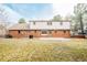 Large backyard featuring a brick house and a concrete patio at 6889 Frying Pan Rd, Boulder, CO 80301