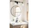 Bright bathroom features a round mirror, modern lighting, and a vanity with a wooden base at 6889 Frying Pan Rd, Boulder, CO 80301