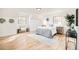 Bedroom with light hardwood flooring, accent furniture, and a cozy bed with grey bedding at 6889 Frying Pan Rd, Boulder, CO 80301