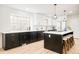 Kitchen featuring white backsplash, black cabinets, island, stainless steel appliances, and hardwood floors at 6889 Frying Pan Rd, Boulder, CO 80301