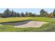 Picturesque golf course featuring a sand trap framed by vibrant green grass and mature trees at 6889 Frying Pan Rd, Boulder, CO 80301