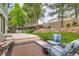 Landscaped backyard with stone patio, seating area, manicured lawn, mature trees, and a privacy fence at 10360 Irving Ct, Westminster, CO 80031