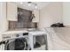 Bright laundry room showcasing modern washer and dryer with overhead cabinets and decorative wall tiles at 10360 Irving Ct, Westminster, CO 80031