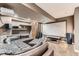 Basement living room with oversized leather couch, projector screen, and carpet at 10360 Irving Ct, Westminster, CO 80031