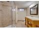 Bathroom with tiled shower, wood vanity, and window at 6095 W 47Th Ave, Wheat Ridge, CO 80033