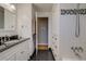 Well-lit bathroom with a black tile floor, featuring a white vanity and a combined shower and bathtub at 6095 W 47Th Ave, Wheat Ridge, CO 80033