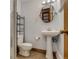 Compact bathroom features tiled floors, toilet, and pedestal sink at 6095 W 47Th Ave, Wheat Ridge, CO 80033