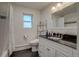 Modern bathroom featuring a sleek black countertop and updated fixtures, with natural light from a window at 6095 W 47Th Ave, Wheat Ridge, CO 80033