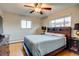 Cozy bedroom with hardwood floors, ceiling fan, and a large bed with a wooden headboard at 6095 W 47Th Ave, Wheat Ridge, CO 80033