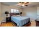 Bedroom with hardwood floors, ceiling fan, a bed with a wooden headboard, and two bedside lamps at 6095 W 47Th Ave, Wheat Ridge, CO 80033