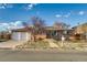 Brick front ranch home with an attached two-car garage and a concrete walk way up to the front door at 6095 W 47Th Ave, Wheat Ridge, CO 80033