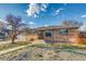 Brick front ranch home with a two-car garage on a sunny day with blue skies and an unfinished yard at 6095 W 47Th Ave, Wheat Ridge, CO 80033