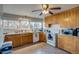 Bright kitchen with wood cabinets, white appliances, tile floors and a large window over the sink at 6095 W 47Th Ave, Wheat Ridge, CO 80033
