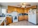 Kitchen with light wood cabinets, white appliances, neutral tile floors and a ceiling fan at 6095 W 47Th Ave, Wheat Ridge, CO 80033
