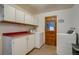 Bright laundry room with white cabinets, red countertop, and washer/dryer units, offering ample storage at 6095 W 47Th Ave, Wheat Ridge, CO 80033