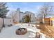 Landscaped backyard with firepit and shed; partially covered in snow at 5418 S Fundy Cir, Centennial, CO 80015