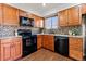 Modern kitchen featuring black appliances and wood cabinets at 5418 S Fundy Cir, Centennial, CO 80015