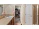Bathroom with vanity and mirror, a doorway to a walk-in closet, and a glass shower in the background at 5591 Canyon View Dr, Castle Rock, CO 80104