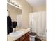 Neutral-toned bathroom features a vanity with wood cabinets, a sink, toilet, and shower-tub combo at 5591 Canyon View Dr, Castle Rock, CO 80104