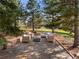 Outdoor patio with stone flooring and comfortable seating arrangement, surrounded by trees and greenery at 6 Blue Grouse Ridge Rd, Littleton, CO 80127