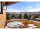 Balcony seating area with city and mountain views, wood construction and string lights at 6 Blue Grouse Ridge Rd, Littleton, CO 80127
