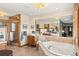 Bright bathroom with soaking tub and shower with glass enclosure at 6 Blue Grouse Ridge Rd, Littleton, CO 80127